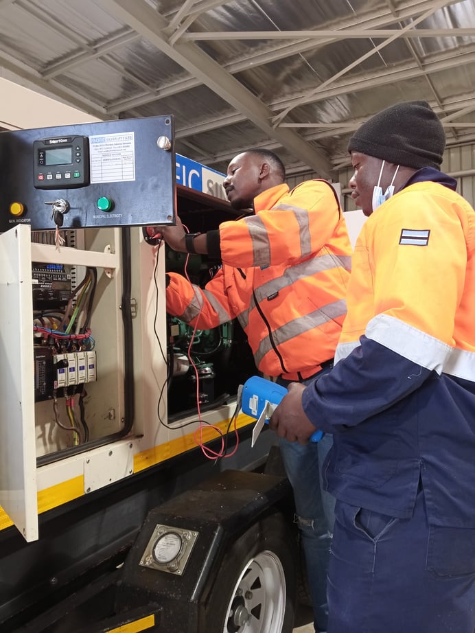 Two Technicians working on a mobile generator